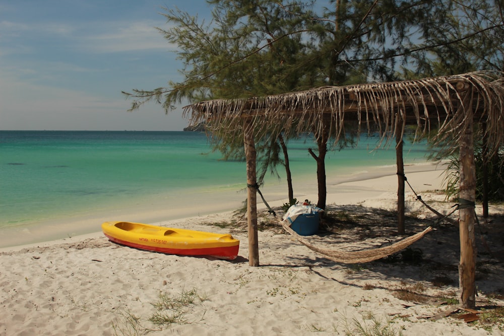 yellow and blue kayak on beach shore during daytime