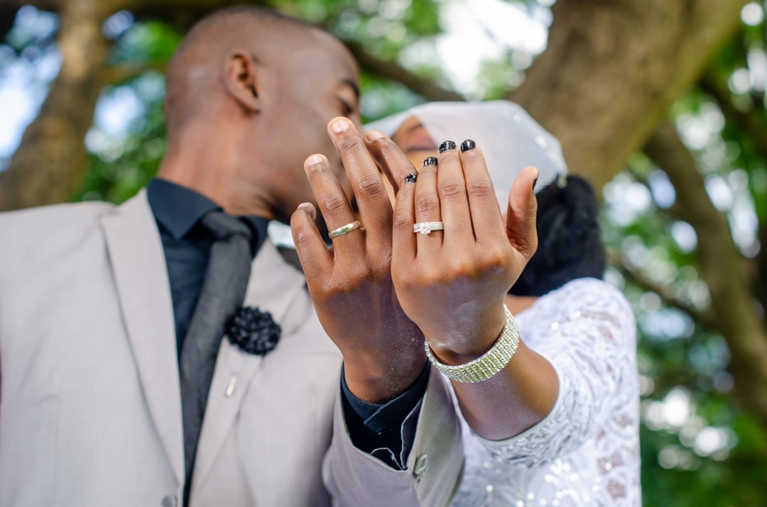 man in black suit jacket kissing womans hand