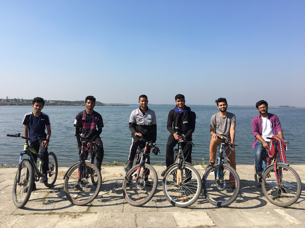 group of people riding bicycle on the road during daytime