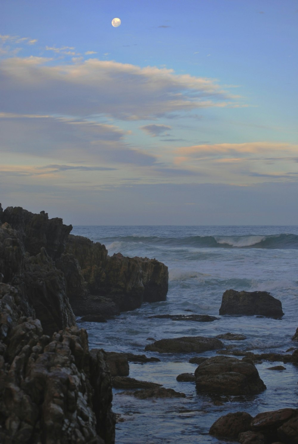 black rock formation on sea during daytime