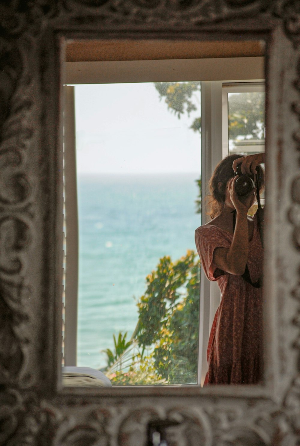 woman in red scarf standing by the window