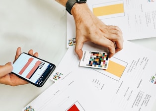 person holding iphone on white printer paper