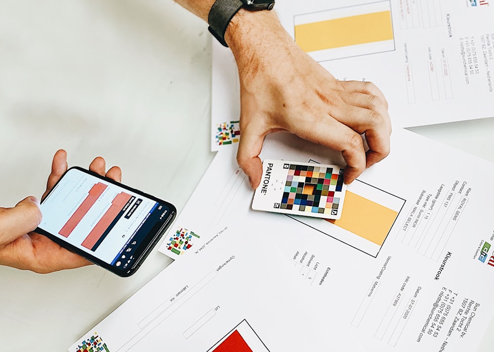 Persona sosteniendo el iPhone en papel blanco de impresora