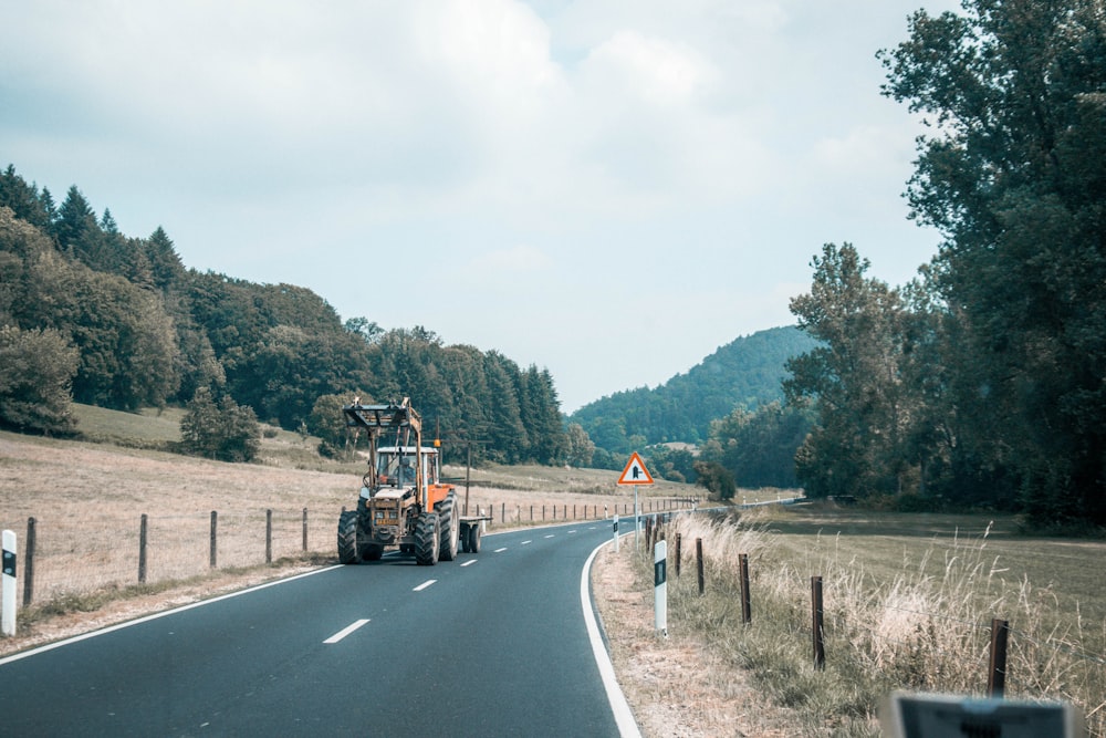 red and black tractor on road during daytime