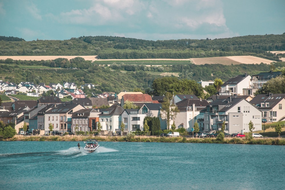 white boat on water near houses during daytime