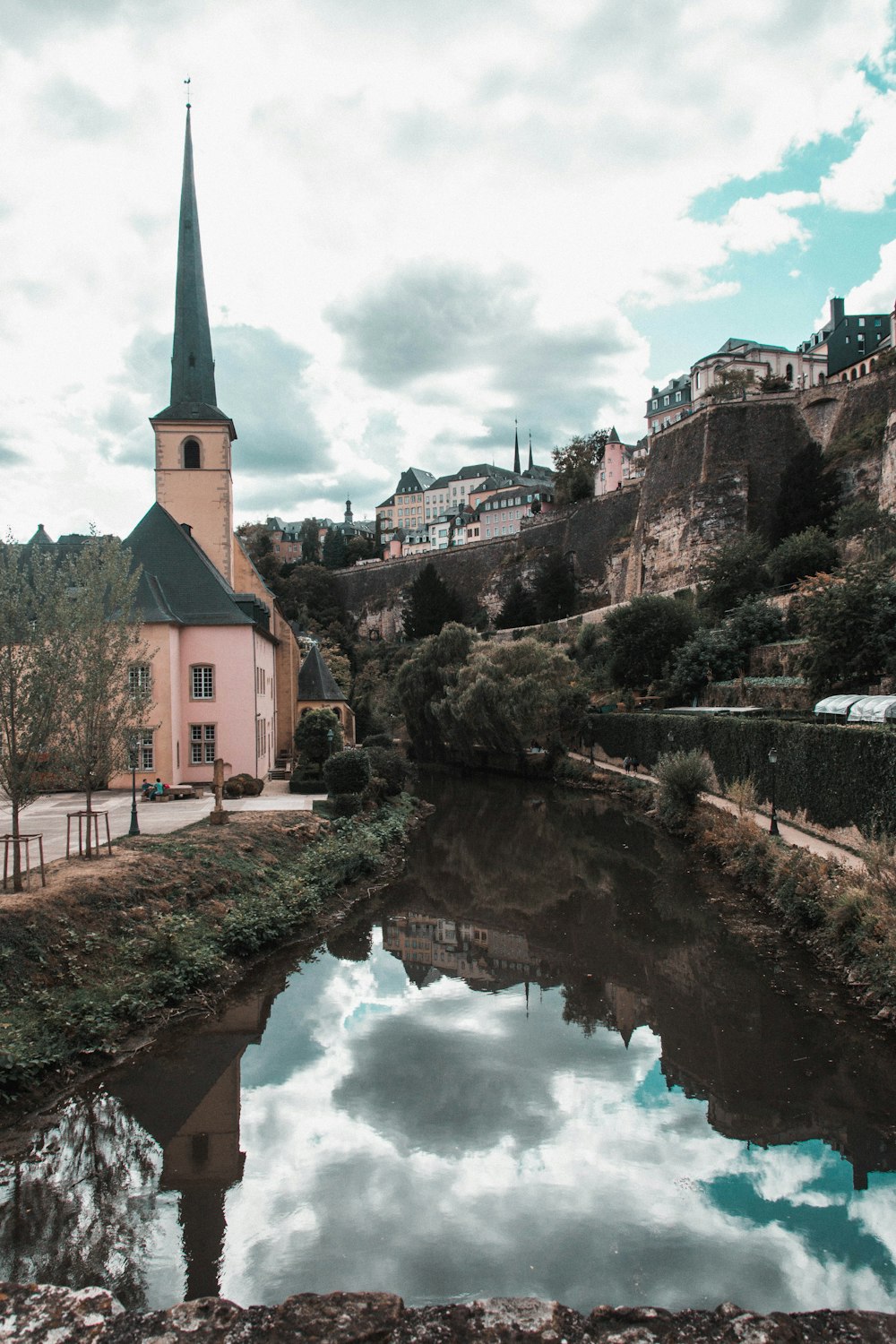 Braunes und grünes Betongebäude in der Nähe des Flusses tagsüber