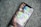 A smartphone resting on a textured fabric surface displays a folder labeled 'Messages' with multiple messaging app icons arranged within. The apps visible are WhatsApp, Telegram, LINE, WeChat, and Signal, each represented by their distinct logos.