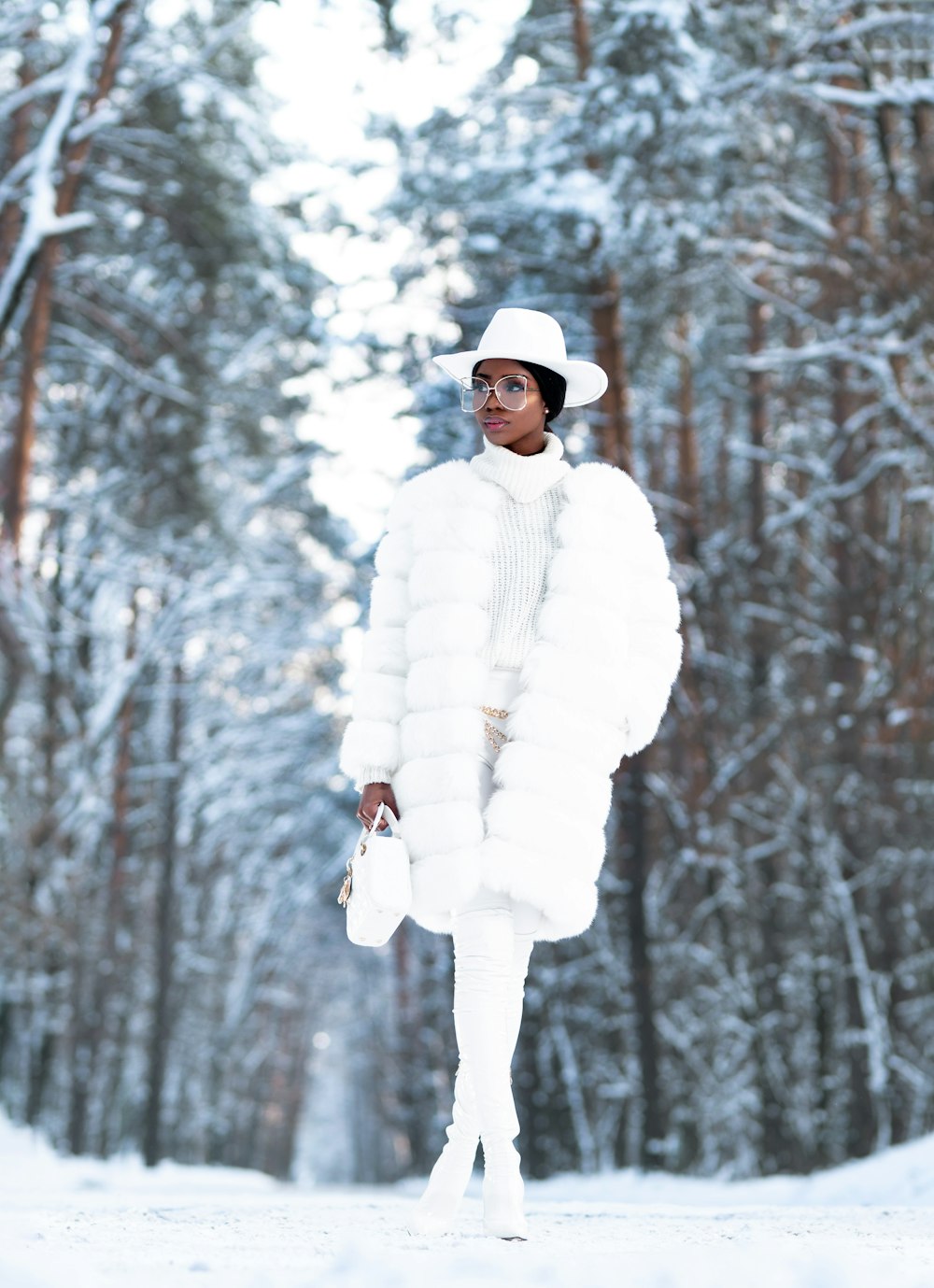 woman in white winter coat standing on snow covered ground during daytime