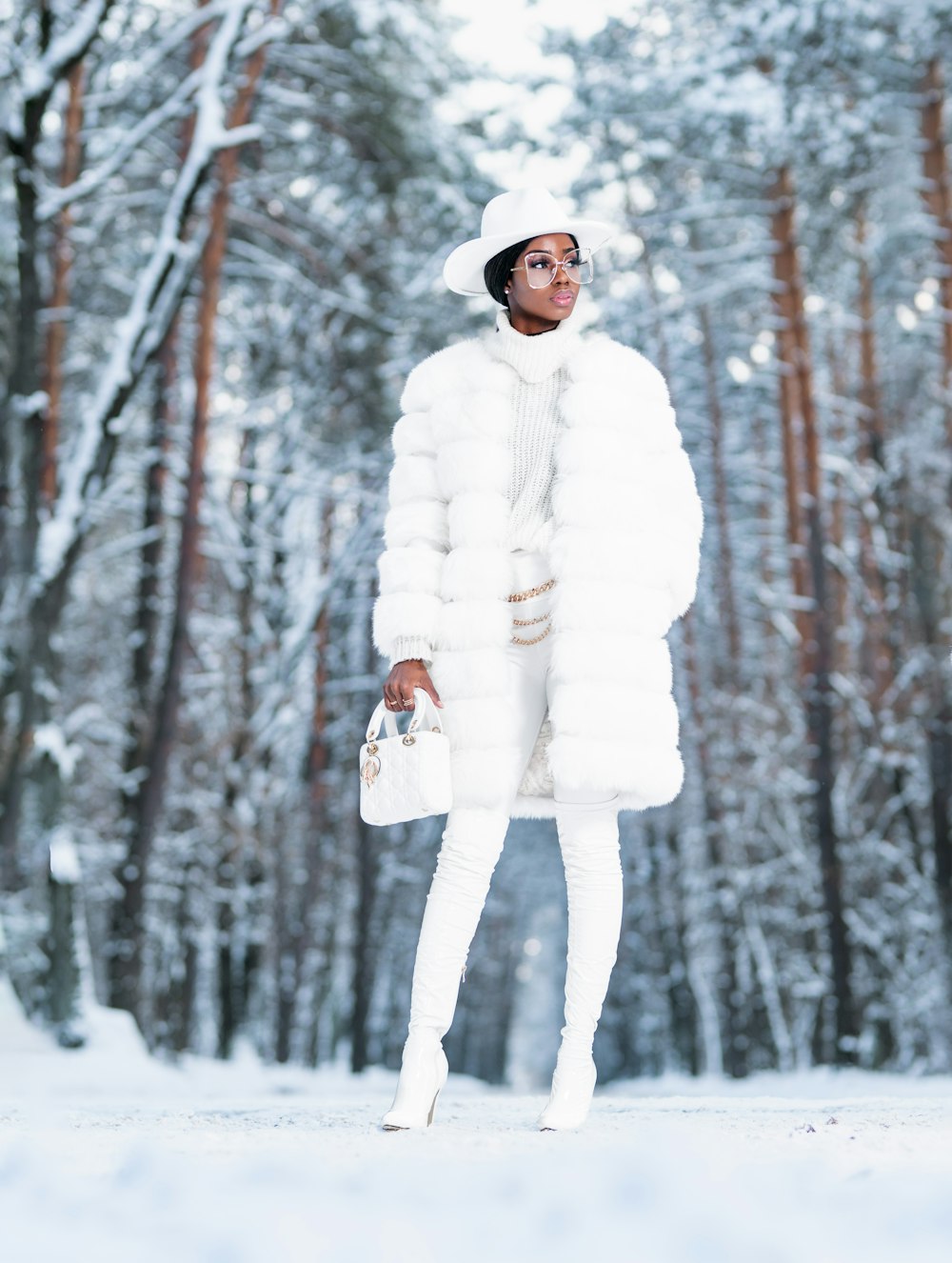 雪に覆われた地面に立つ白衣の女性