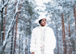 woman in white coat standing on snow covered ground