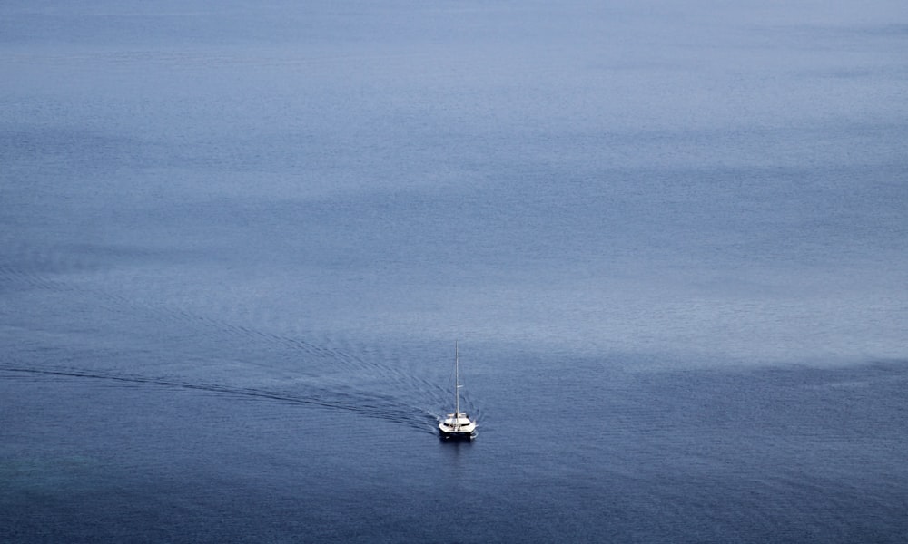 barco branco no mar azul sob o céu azul durante o dia