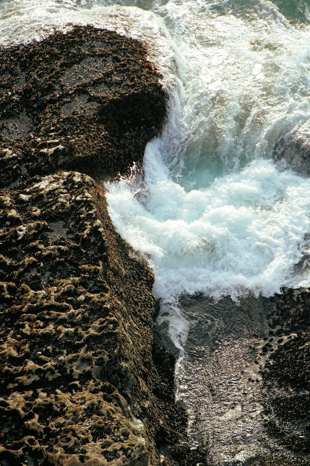 water falls on brown rocky mountain during daytime