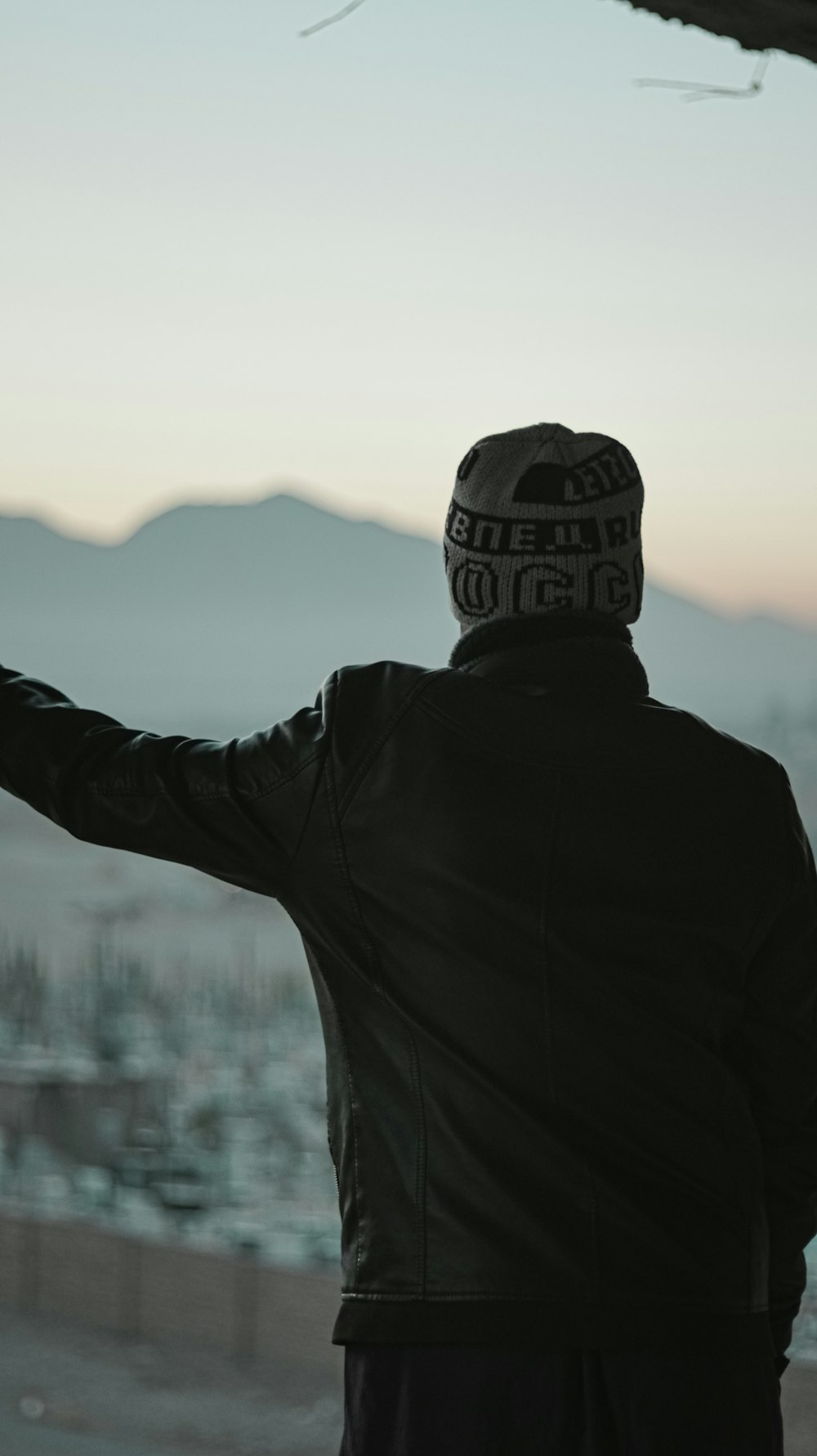 Hombre con chaqueta negra y gorra de punto marrón y negro