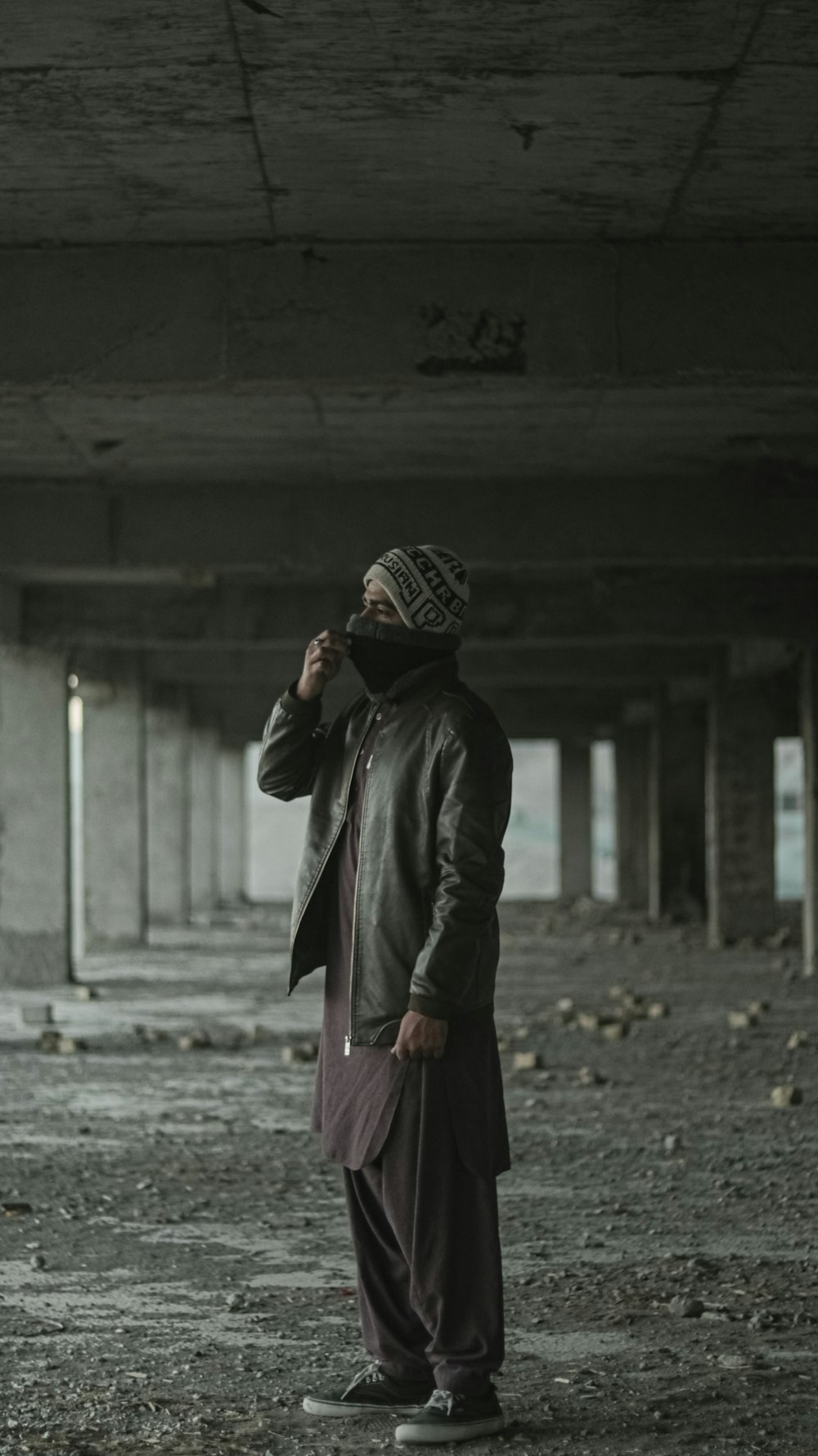 woman in black coat standing on gray concrete floor