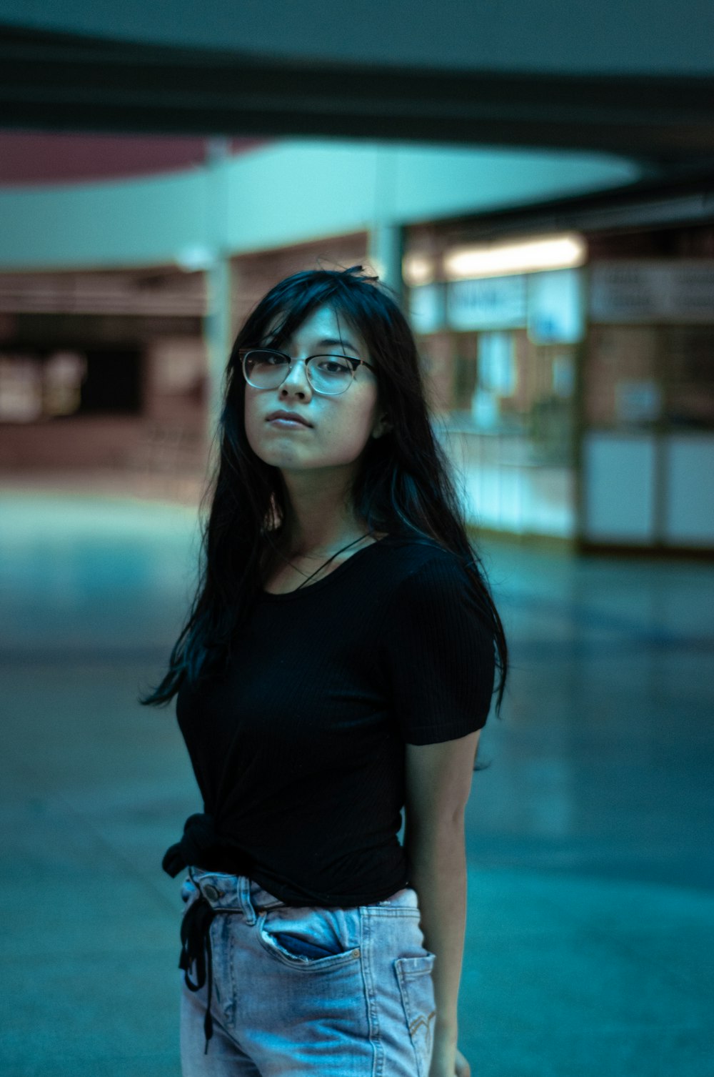 woman in black crew neck t-shirt and black pants wearing black framed eyeglasses