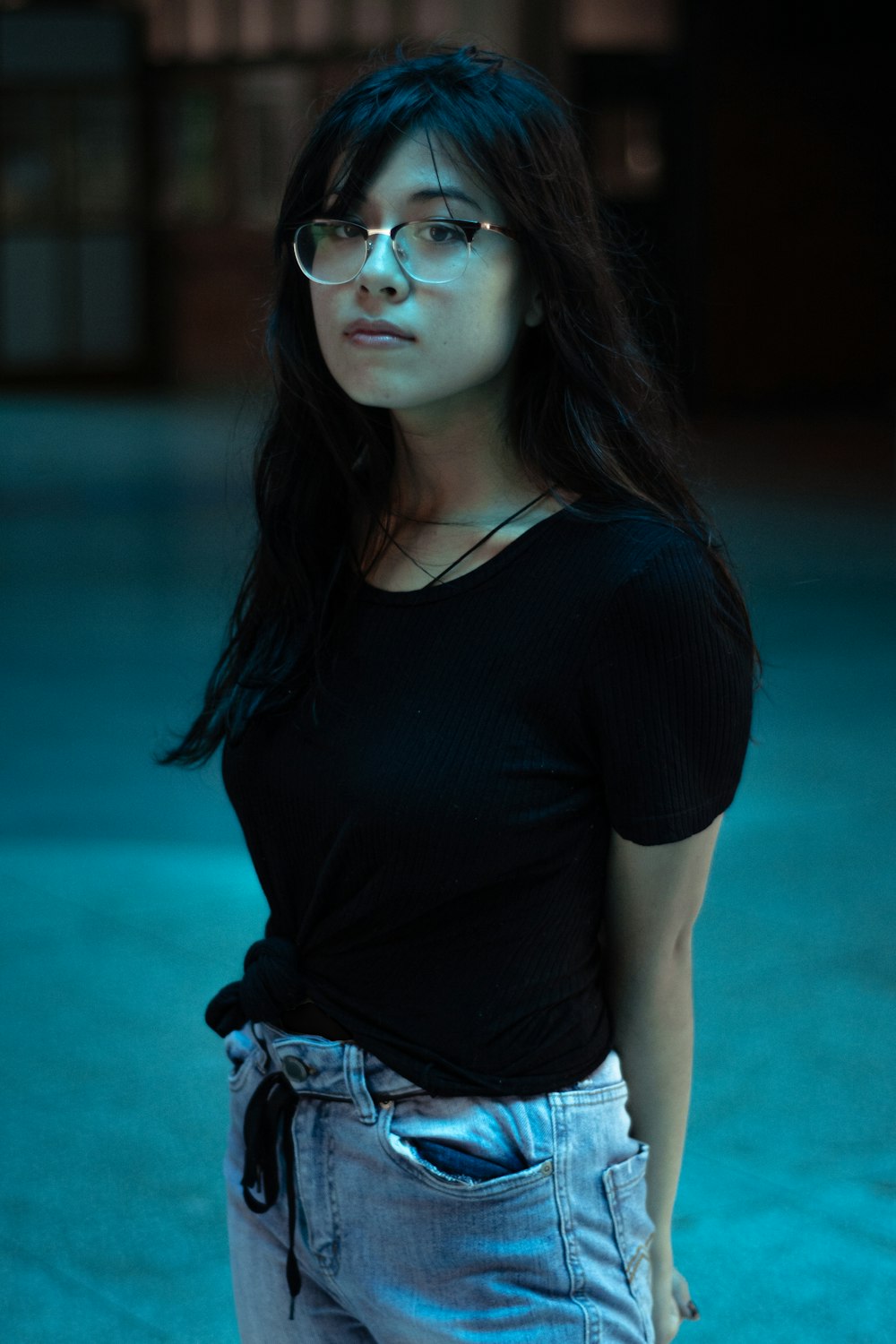 woman in black v neck t-shirt and blue denim jeans wearing sunglasses