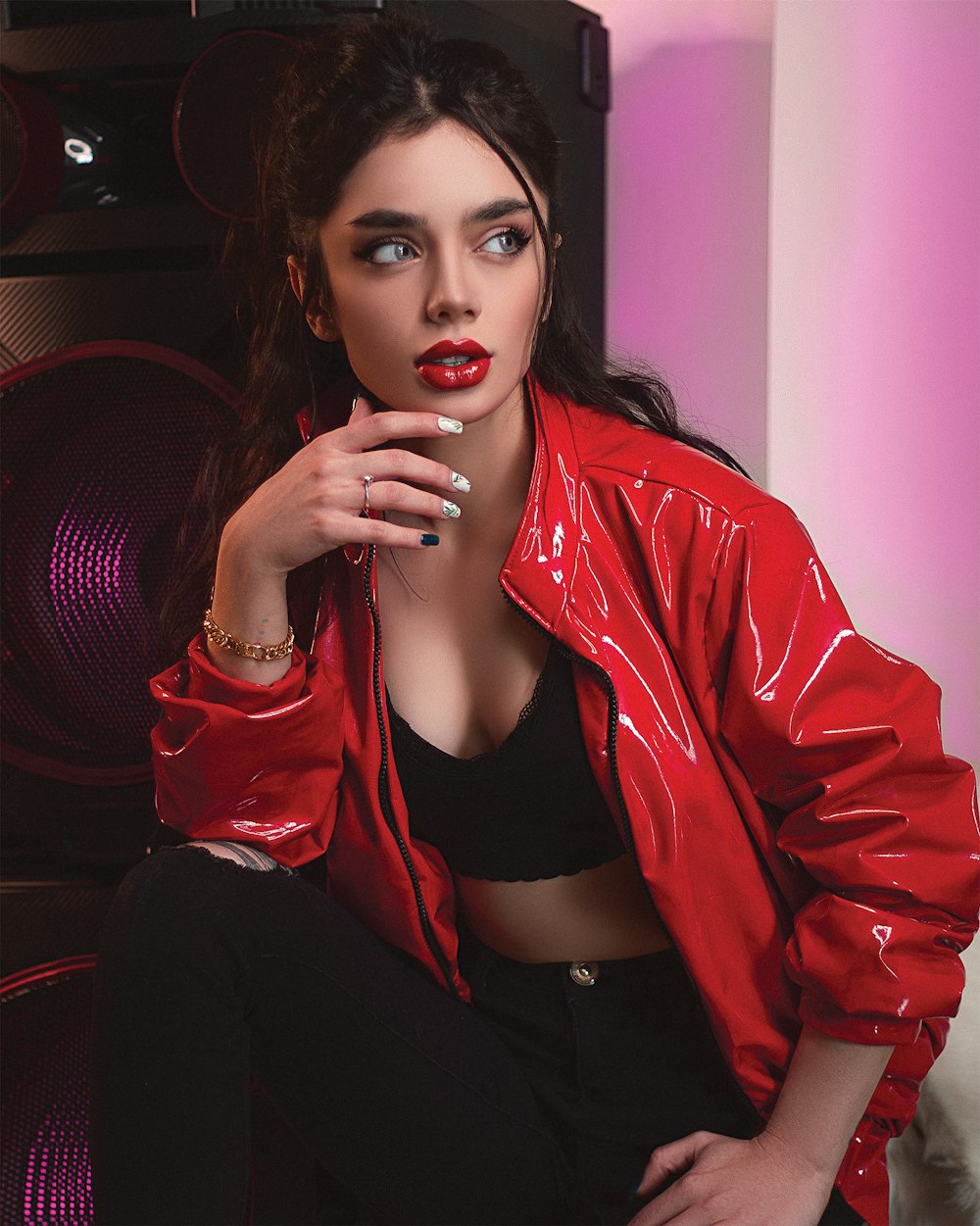 woman in red leather jacket and black pants sitting on red sofa