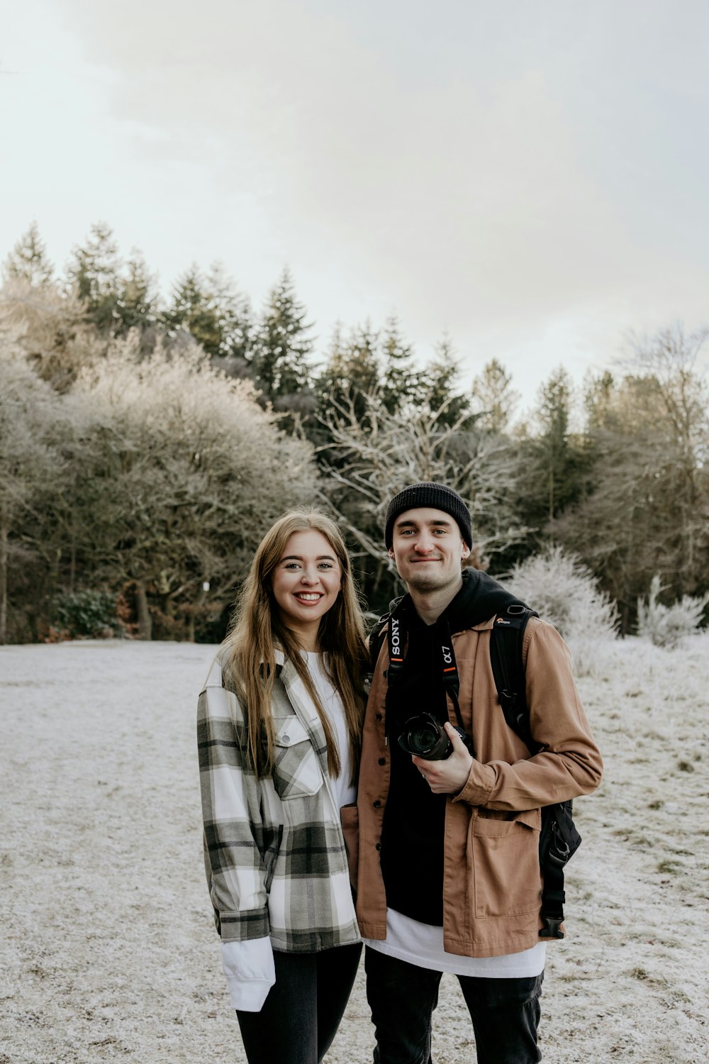 2 women standing on snow covered ground during daytime