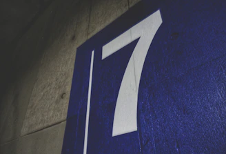 A freshly painted curb showing a clear house number alongside a vibrant sports team logo.