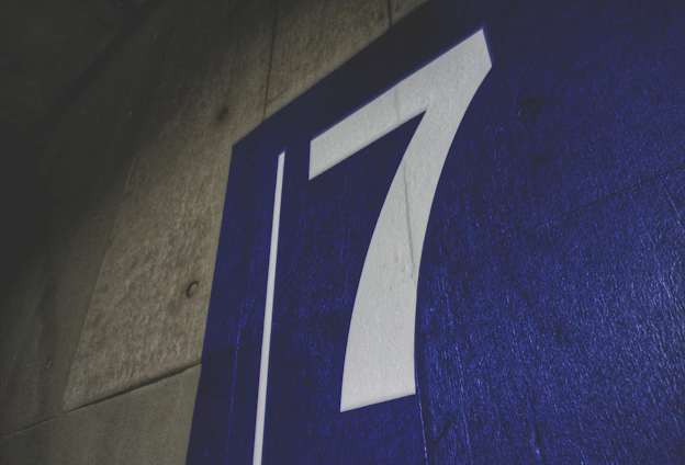 A freshly painted curb showing a clear house number alongside a vibrant sports team logo.