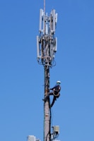 A technician performing maintenance on a tall communication tower.