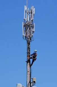 Technician safely working at height on a telecom tower.