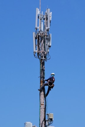 Close-up of workers installing antenna equipment on a communication tower.