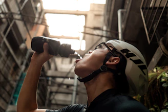 Close-up of a cyclist drinking water and energy gel during a ride.