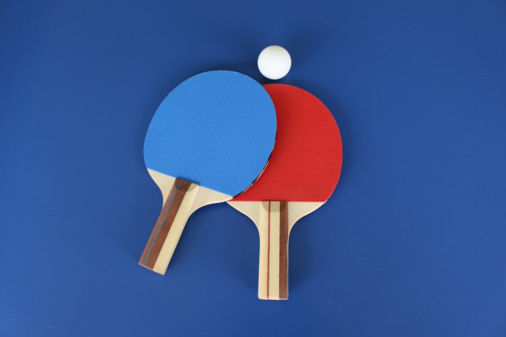 red and white wooden table tennis racket