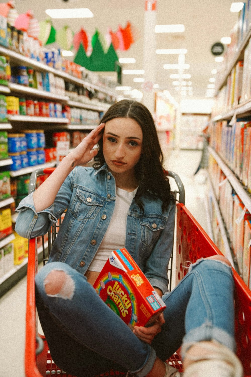 woman in blue denim jacket holding red and blue book