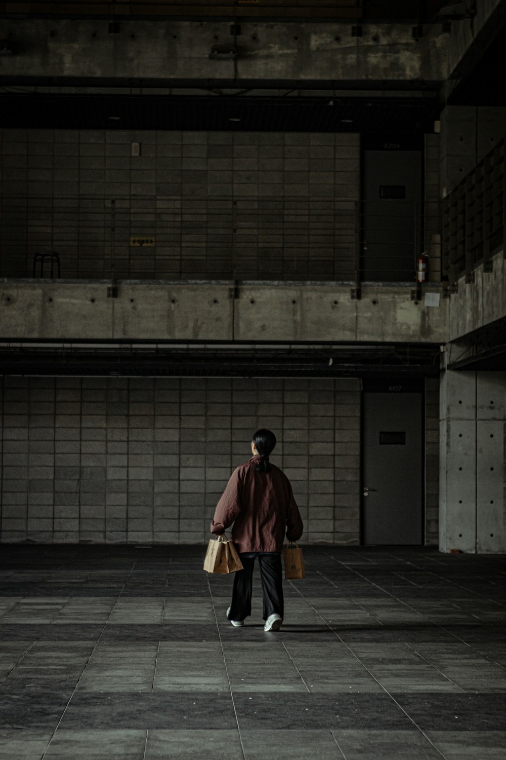 man in brown coat walking on sidewalk during daytime