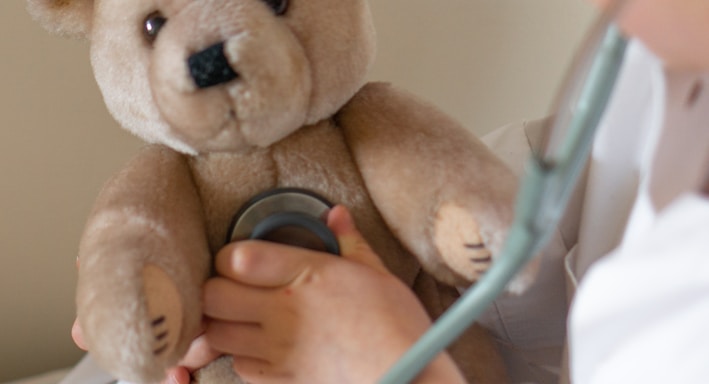 person holding brown bear plush toy