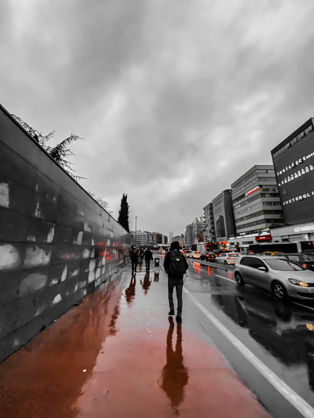 person in black jacket and red pants walking on street during daytime