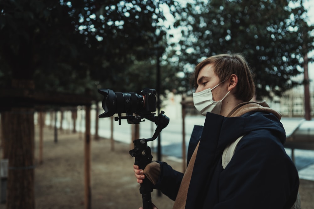 woman in black blazer holding black dslr camera