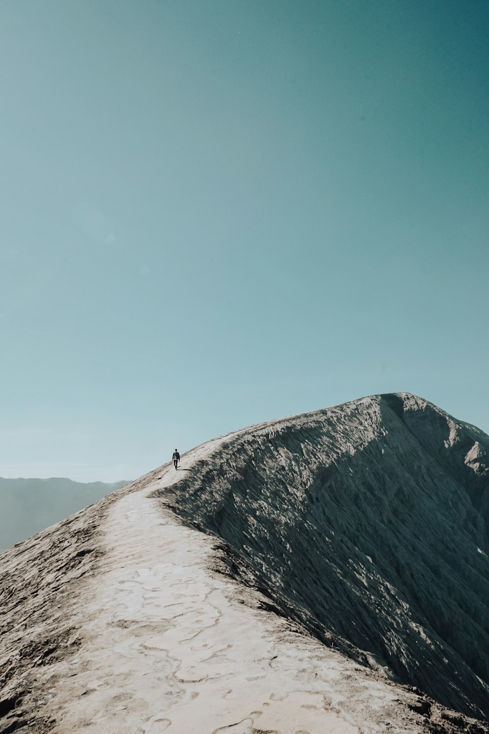 person standing on top of mountain during daytime