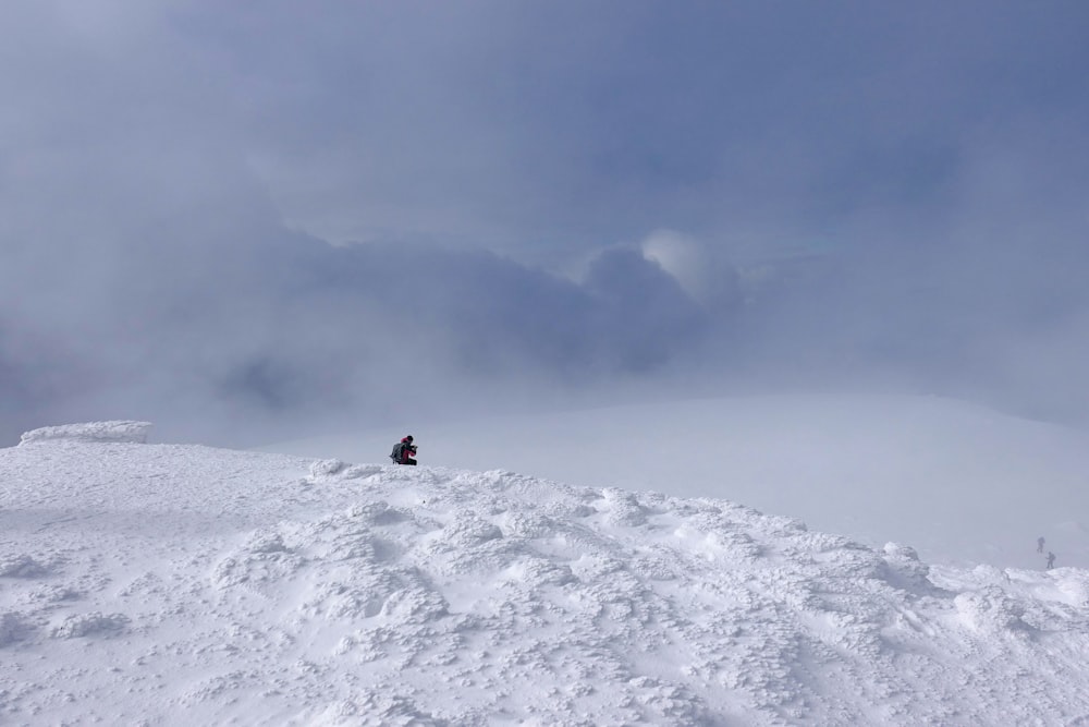 person in black jacket standing on snow covered ground during daytime