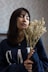 woman in blue and white long sleeve shirt holding yellow flower