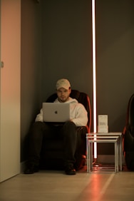 man in red long sleeve shirt using macbook