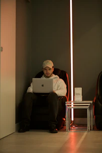 man in red long sleeve shirt using macbook
