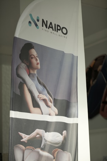 A banner displays a promotional image featuring a person enjoying a neck and shoulder massager. The top part of the banner includes the logo and slogan of the brand Naipo, with the tagline 'Find Well-being'. The model appears to be relaxed and comfortable, reinforcing a sense of tranquility.