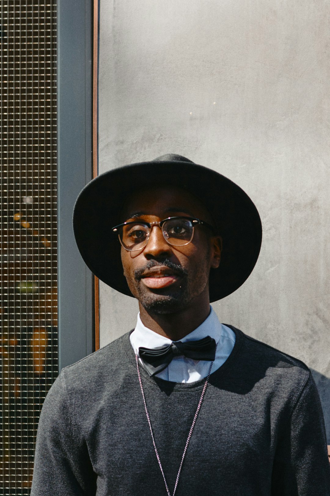 man in gray suit wearing black hat and black sunglasses