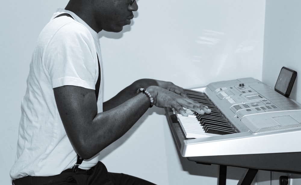 man in white t-shirt playing piano