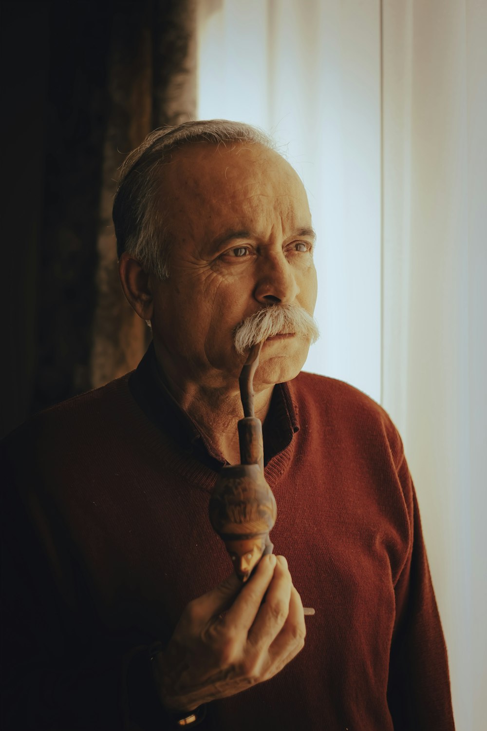 man in red crew neck shirt holding brown hookah