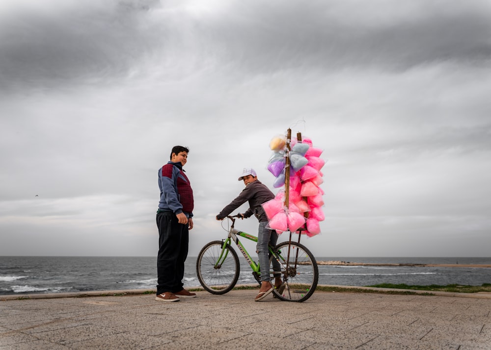 man and woman riding bicycle on beach during daytime