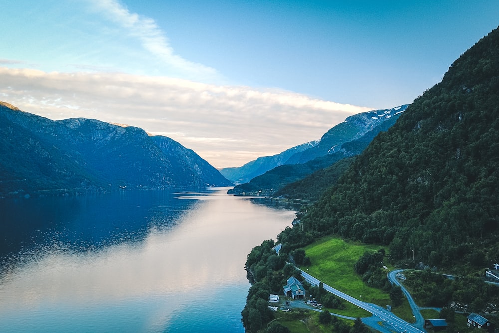 green mountains beside lake under blue sky during daytime