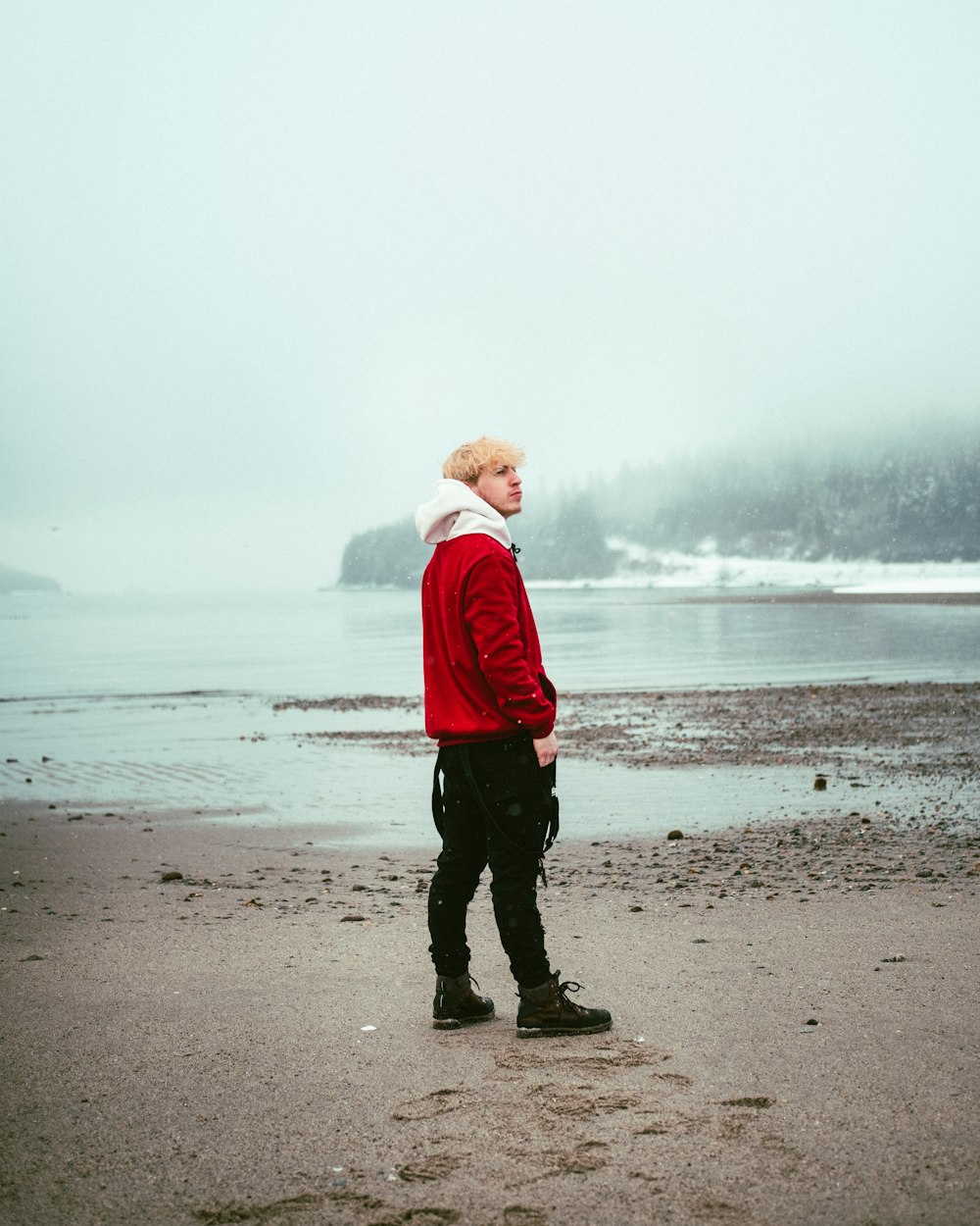 boy in red hoodie standing on beach during daytime