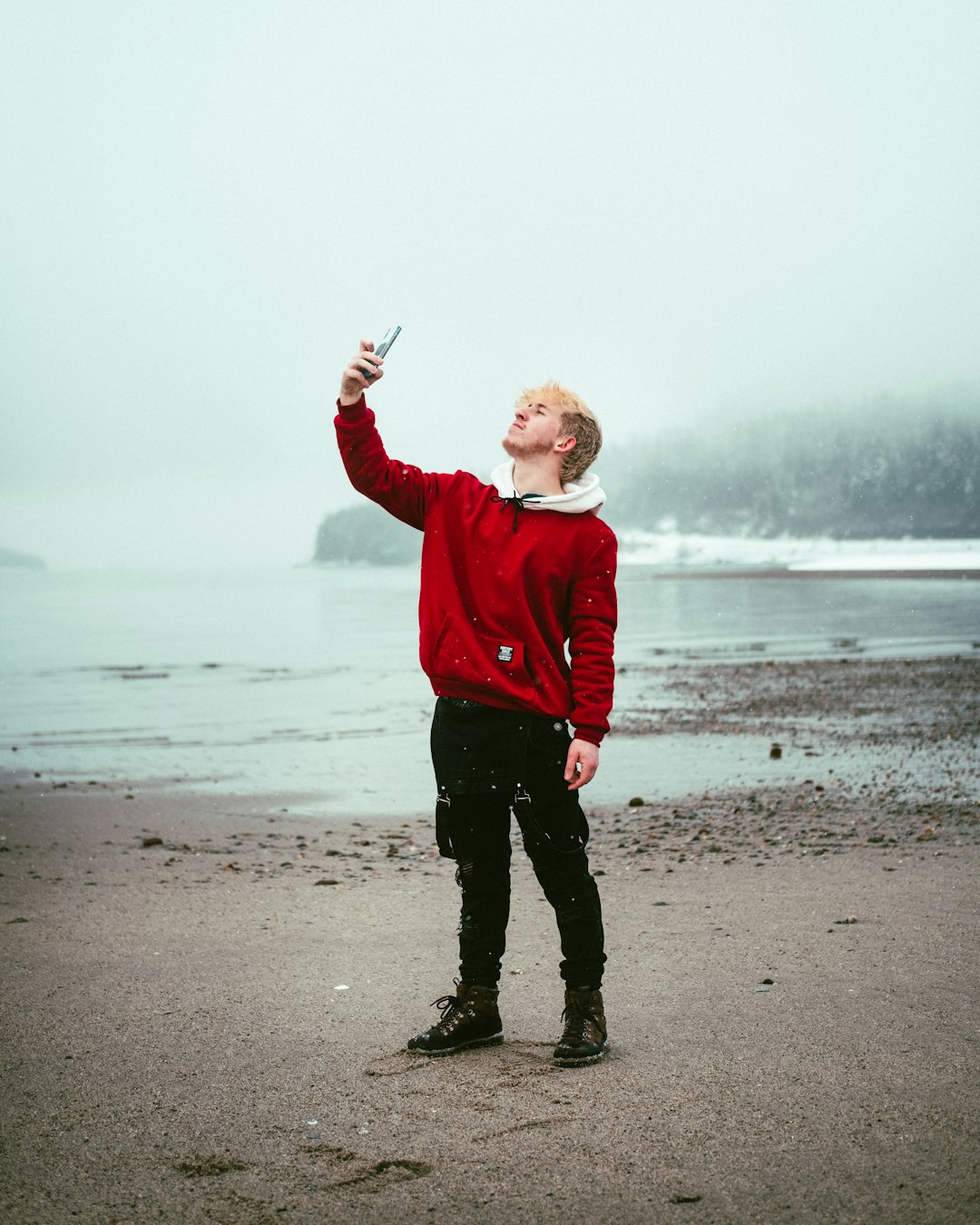 girl in red jacket standing on beach during daytime