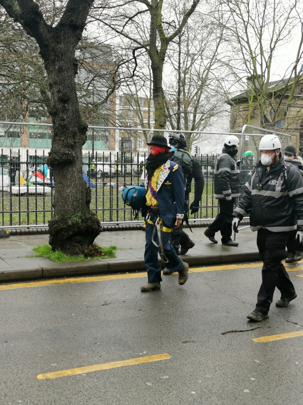 pessoas em jaqueta verde andando na faixa de pedestres durante o dia