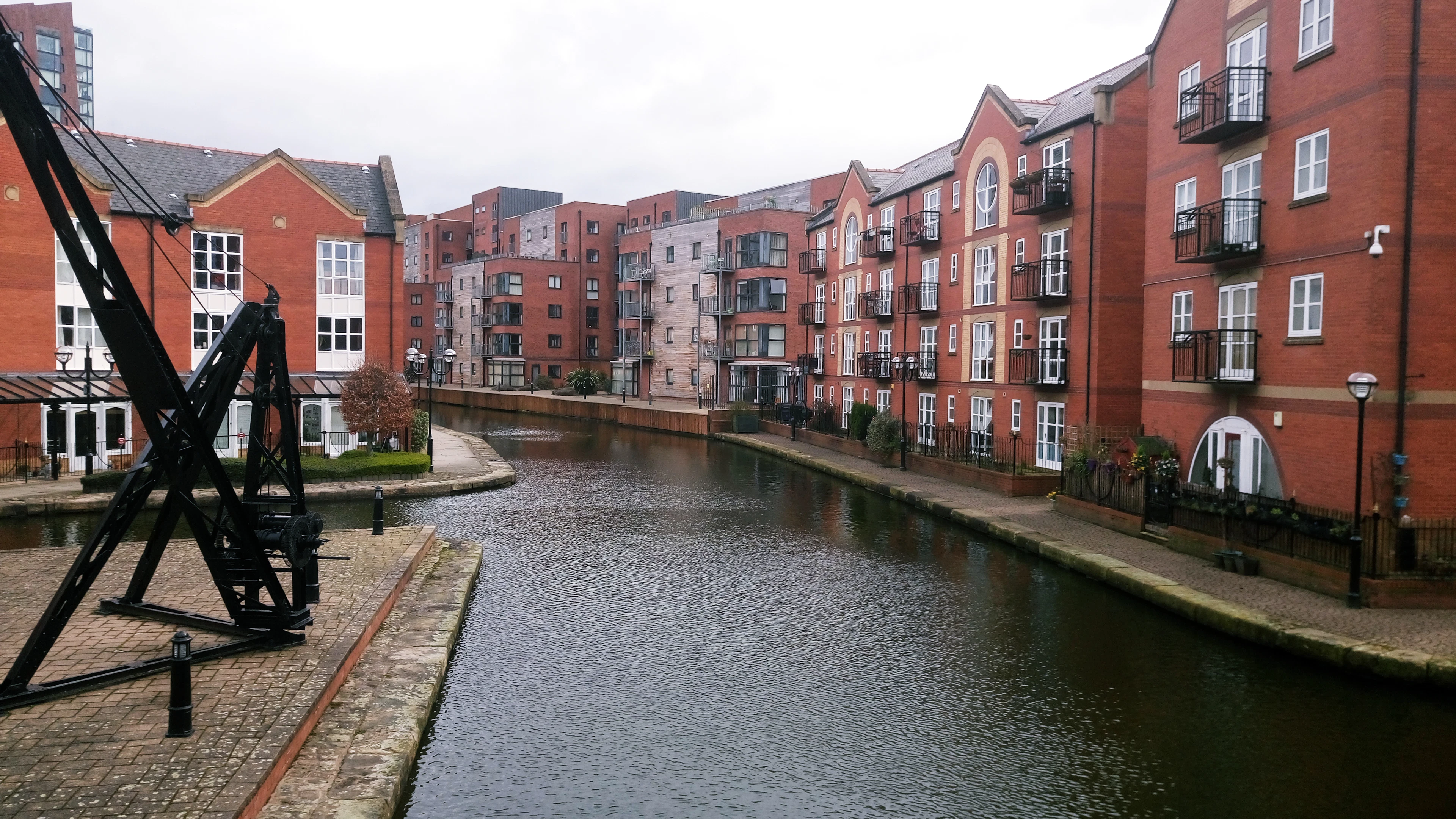 The Castlefield canal in Manchester, brick warehouses and an old crane along the bank