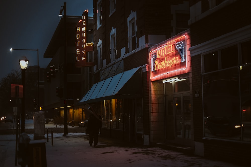 man in black jacket walking on sidewalk during night time